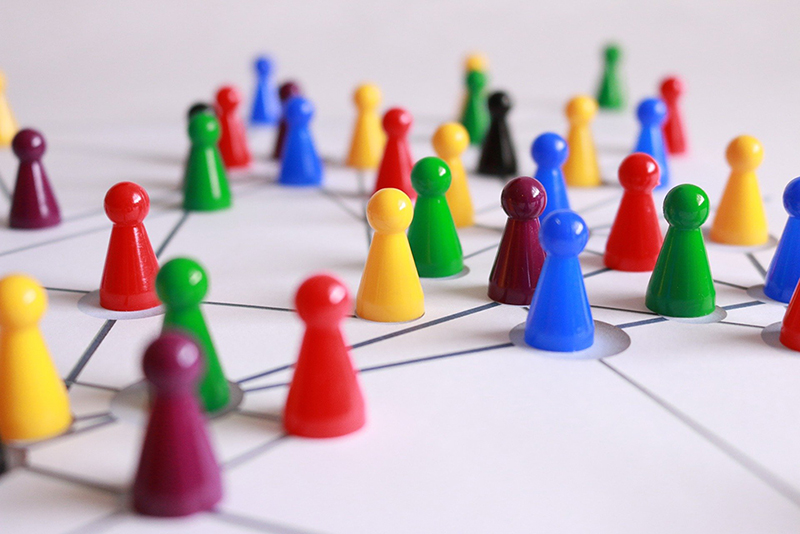 bunte Spielfiguren stehen auf einem Netz aus Linien